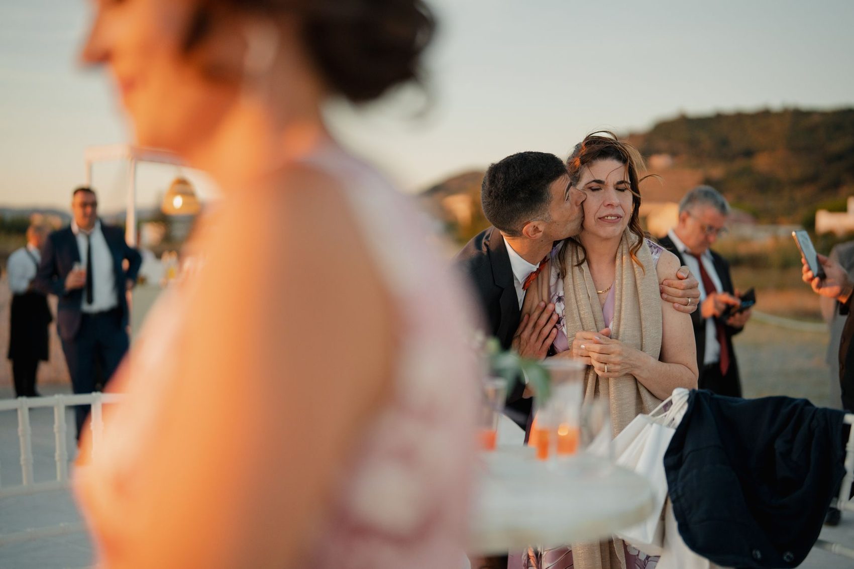 Guests at an outdoor reception with hills behind